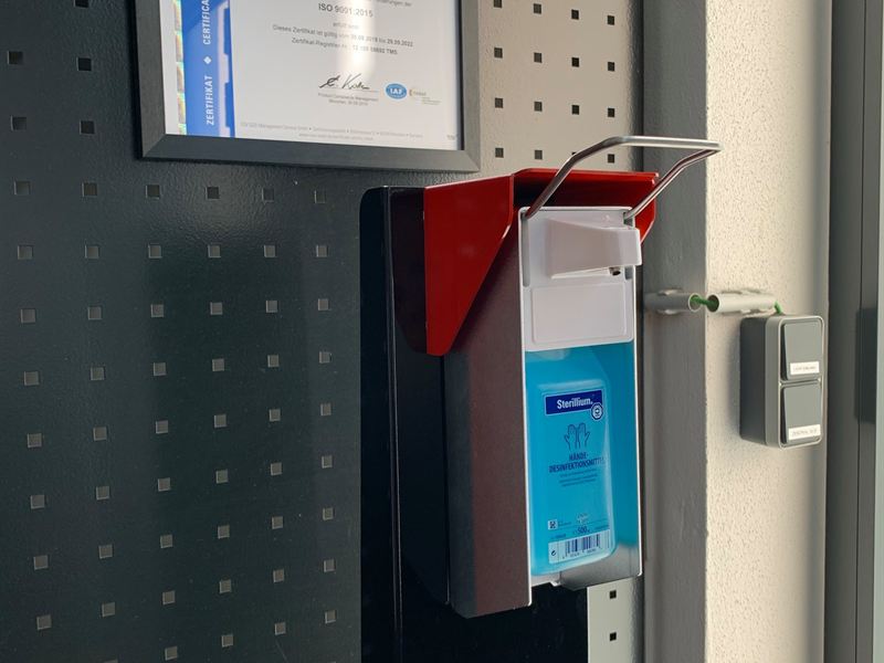 Wandmontierter Desinfektionsmittelspender aus gelochtem Blech